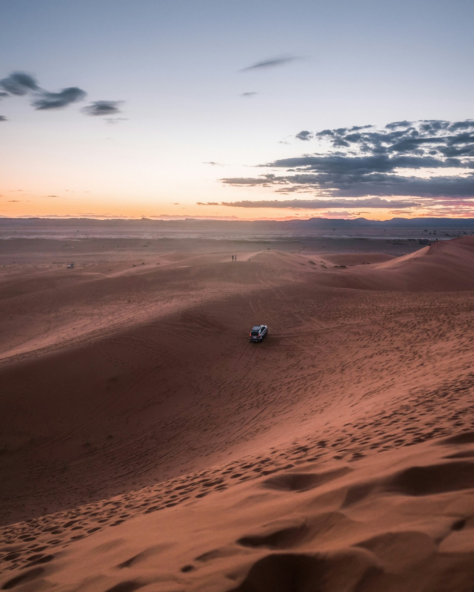 Traveller walking the ridge of a sand dune in Merzouga
